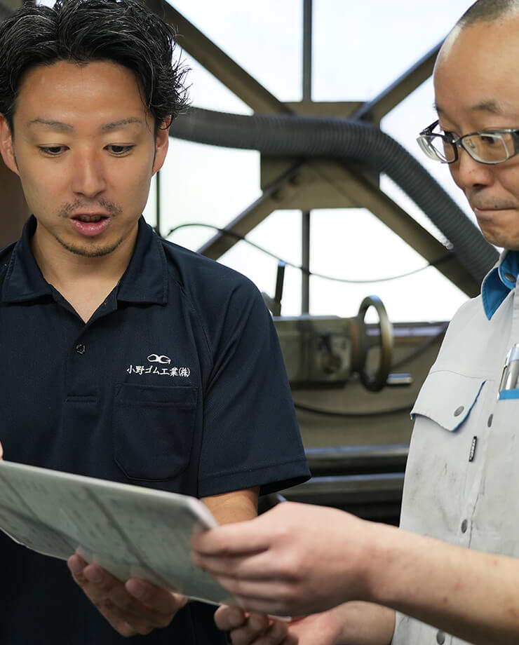 立ちながら打ち合わせをする男性二人