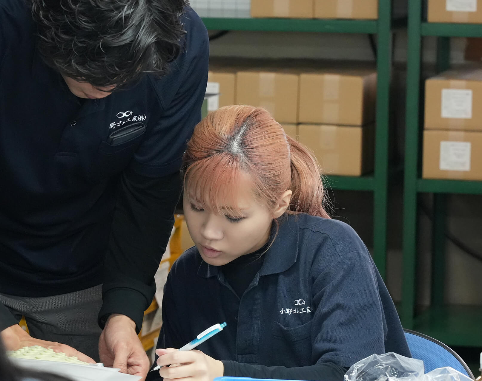 女性社員と男性社員が打ち合わせをする様子